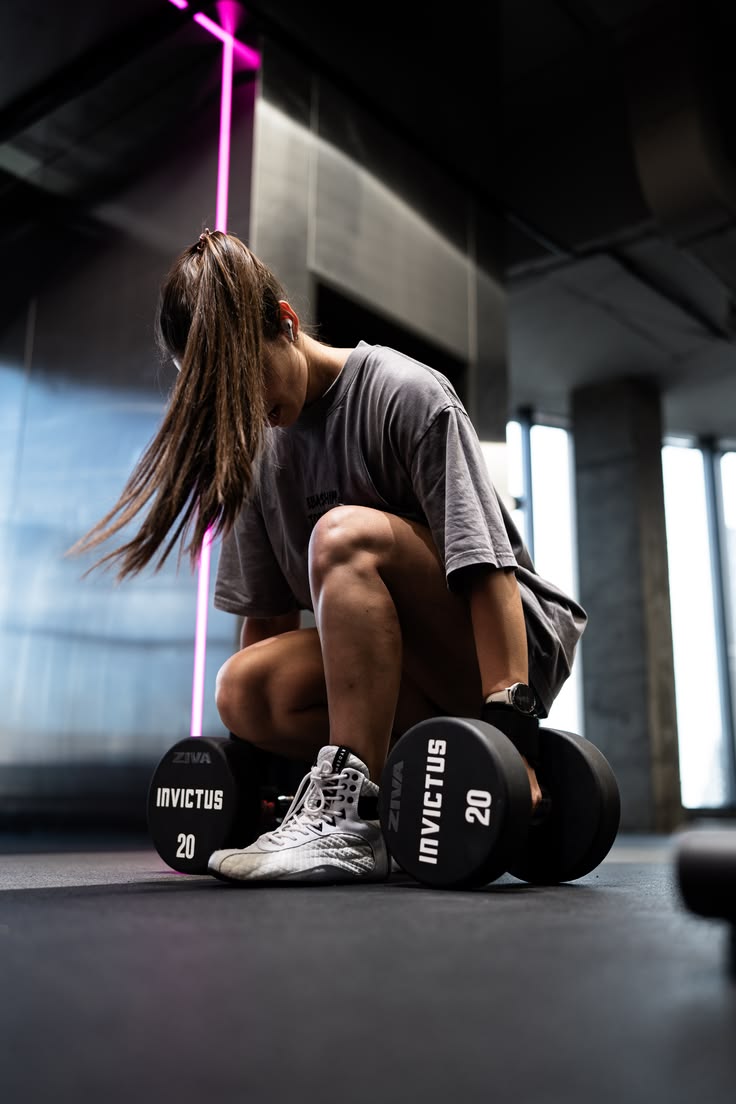 Aluna da Arena Academia treinando com halteres